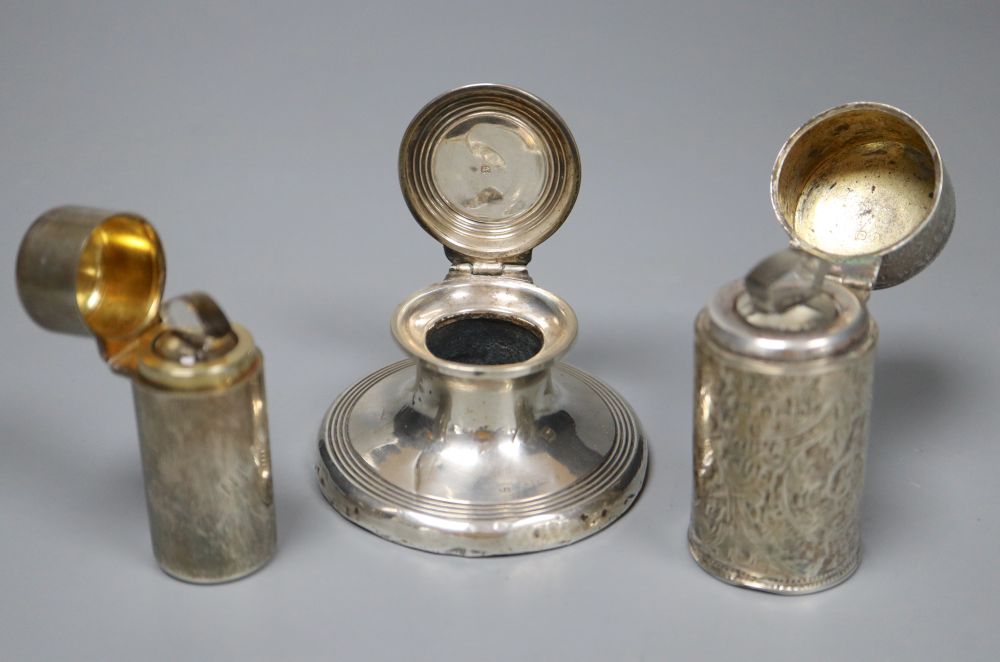 A silver capstan inkwell and two silver-cased cylindrical scent bottles